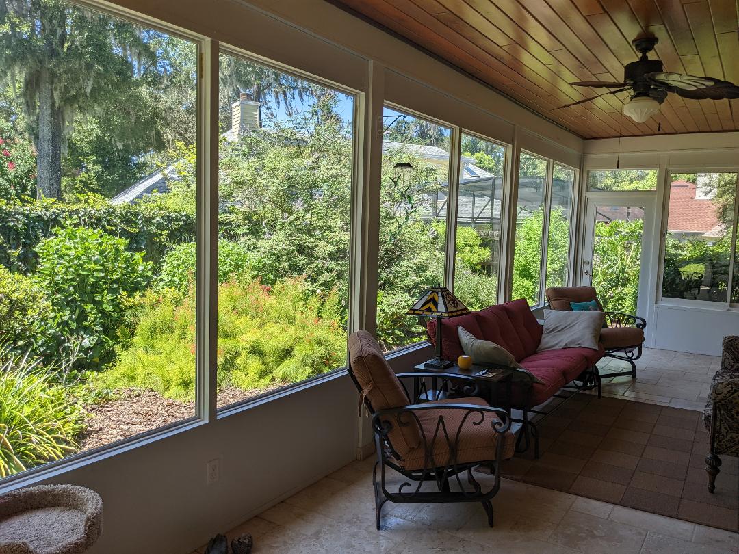 Sunroom with large windows and garden view.