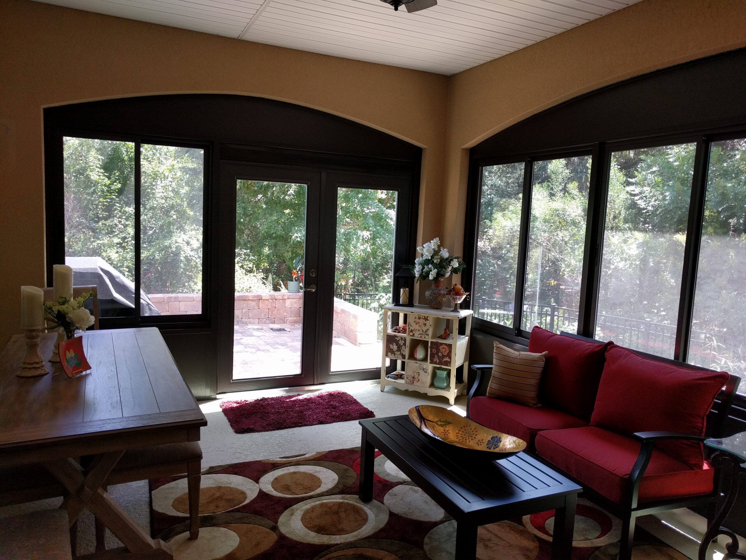 Sunlit room with red couch and table.